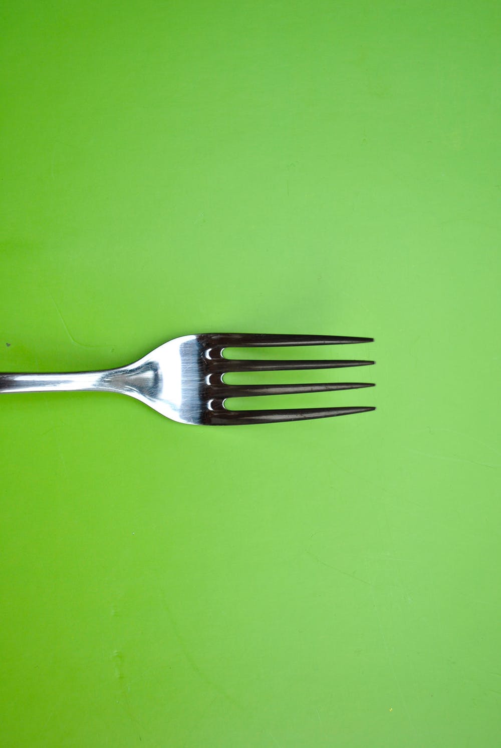 A fork on a green background.